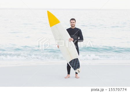 Man in wetsuit with a surfboard on a sunny day 15570774