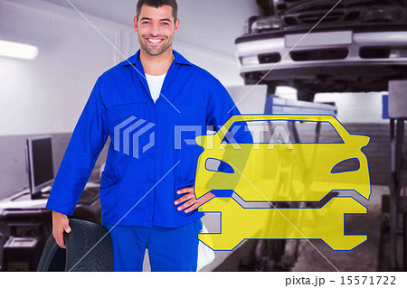 Composite image of smiling male mechanic holding tire 15571722