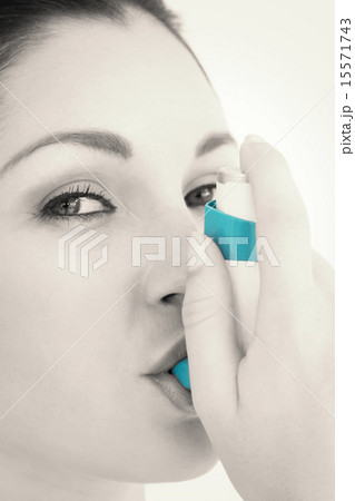 Happy woman using asthma inhaler Happy woman using asthma inhaler 15571743