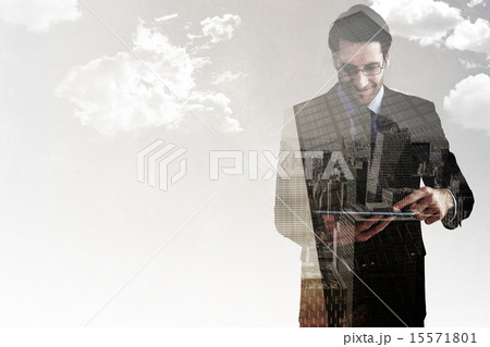 Composite image of businessman standing while using a tablet pc 15571801