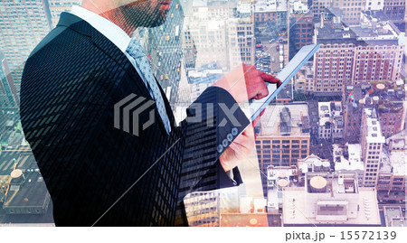 Composite image of businessman using his tablet pc 15572139