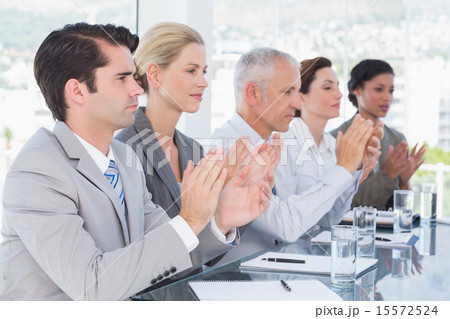 Business team applauding during conference 15572524