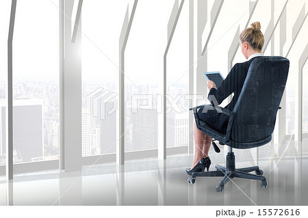 Composite image of businesswoman sitting on swivel chair with ta 15572616
