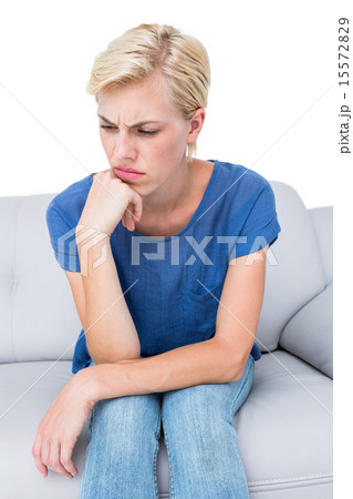Thoughtful blonde woman sitting on the couch 15572829