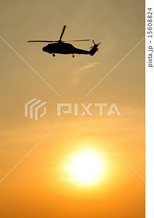 美しい夕日を背景に飛行する東日本大震災等でも活躍した米海軍SH-60Bシーホーク艦上対潜ヘリコプター 15608824