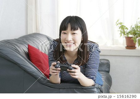 テレビゲームに夢中の若い女性 15616290
