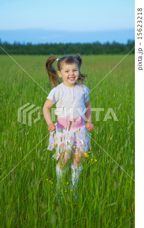 Happy child jumps on green grass in field Happy child jumps on green grass in field 15623218