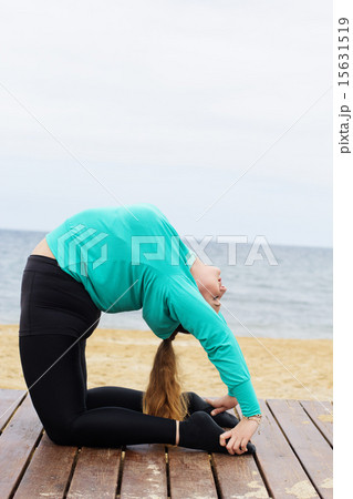 Plump woman doing hatha yoga asana near the sea 15631519