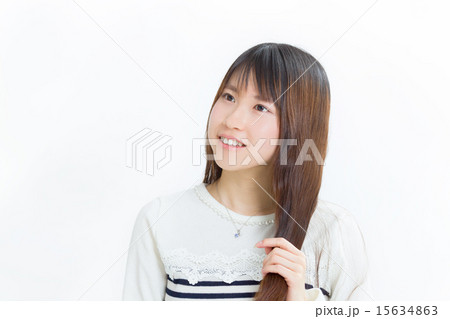 爽やかな服を着て手ぐしで髪を触る可愛い女の子の写真素材