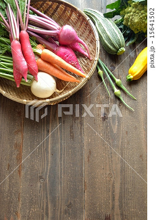 ざるに入ったカラフルな根菜と初夏の野菜の写真素材