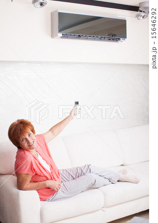 Woman holding a remote control air conditioner Woman holding a remote control air conditioner 15646292