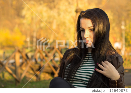 beautiful and sexy girl sitting on bench outdoors 15649878