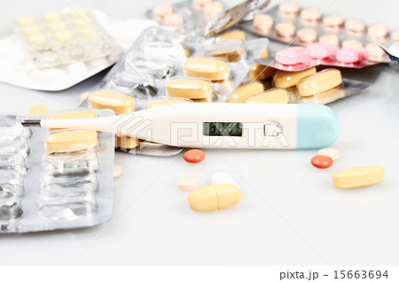 Thermometer and pills isolated on white 15663694