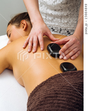 Massage therapist placing the hot stones 15664849