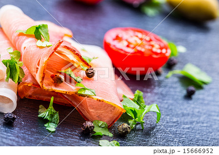 Curled Slices of Delicious Prosciutto with parsley 15666952