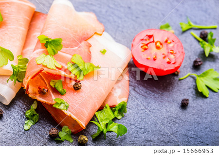 Curled Slices of Delicious Prosciutto with parsley 15666953