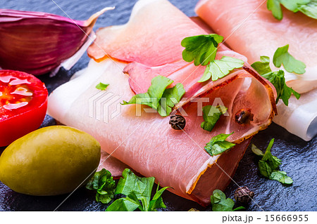Curled Slices of Delicious Prosciutto with parsley 15666955