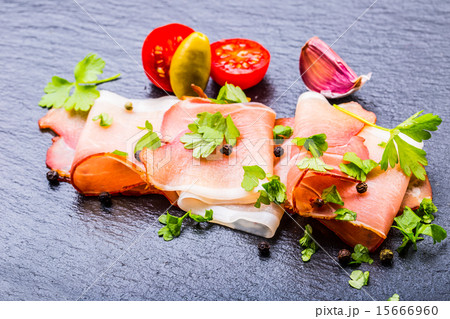Curled Slices of Delicious Prosciutto with parsley Curled Slices of Delicious Prosciutto with parsley 15666960