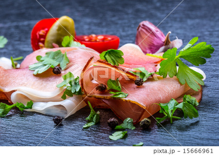Curled Slices of Delicious Prosciutto with parsley Curled Slices of Delicious Prosciutto with parsley 15666961
