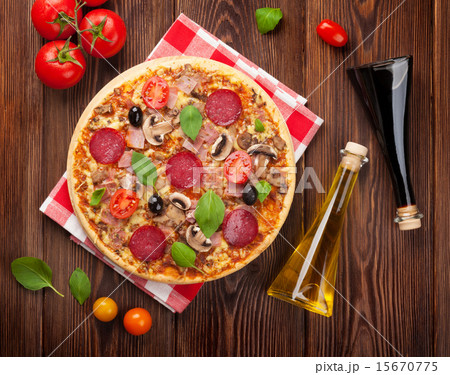 Italian pizza with pepperoni, tomatoes, olives  15670775