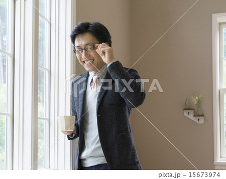 カップを持って笑う男性 15673974