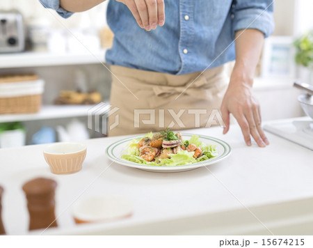 料理を盛り付ける男性の手 15674215