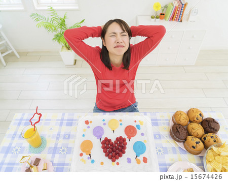 ケーキを前に頭を抱える女性 15674426