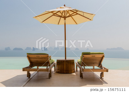 infinity pool with parasol and sun beds at seaside 15675111