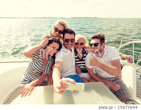 smiling friends sitting on yacht deck 15675644