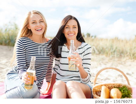 happy young women drinking beer on beach 15676075