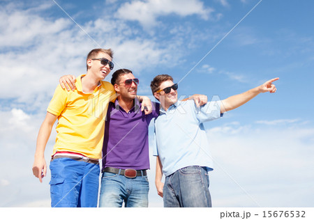 smiling friends in sunglasses pointing finger 15676532