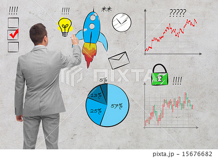 businessman pointing to business symbols from back 15676682