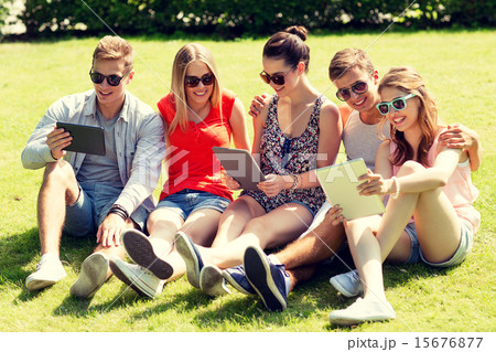 smiling friends with tablet pc computers in park 15676877