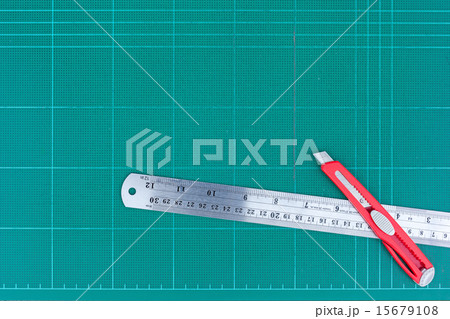 A ruler and cutter on green cutting mat 15679108