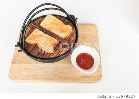 Toast on black iron bowl and tomato sauce on wood 15679327