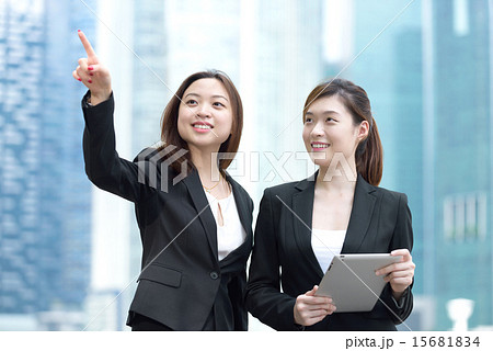 2 Chinese businesswoman with iPad meeting outdoors 15681834