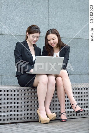 2 Chinese woman using laptop outdoors 2 Chinese woman using laptop outdoors 15682022