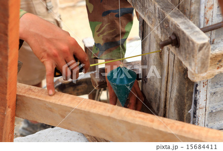 labor man using a plumb bob for check . 15684411