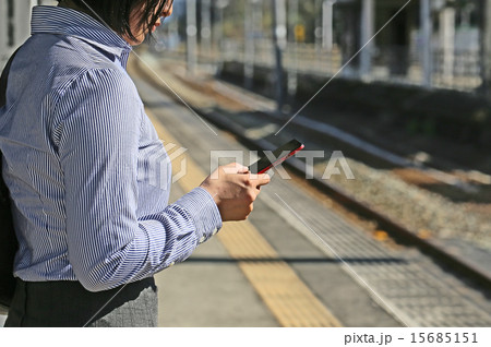 駅のホームでスマートフォン操作 15685151