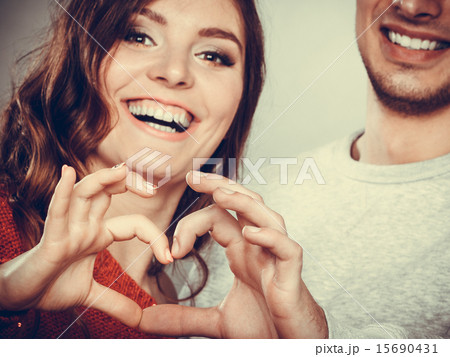 Young couple making heart shape by hands Young couple making heart shape by hands 15690431