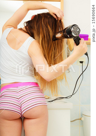 long haired woman drying hair in bathroom rear view long haired woman drying hair in bathroom rear view 15690664