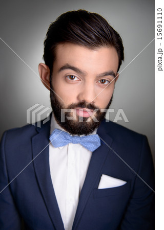 Stylish man with beard and bow tie looking at camera 15691110