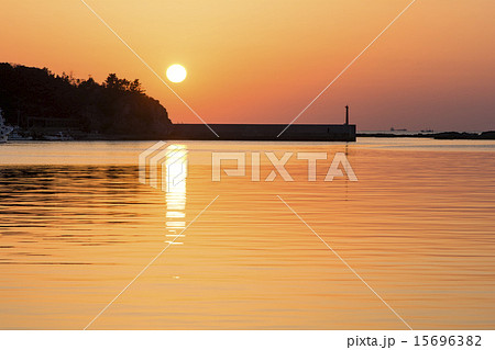 堤防と夕陽の落ちる海 15696382