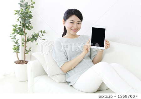 笑顔でタブレット画面を見せる女性　　　　 15697007