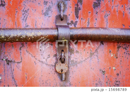 Old rusted padlock on red metal door Old rusted padlock on red metal door 15698789