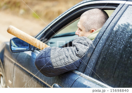 Aggressive man with a baseball bat in car 15698840