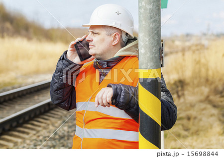 Railway employee talking on cell phone near railwa Railway employee talking on cell phone near railwa 15698844