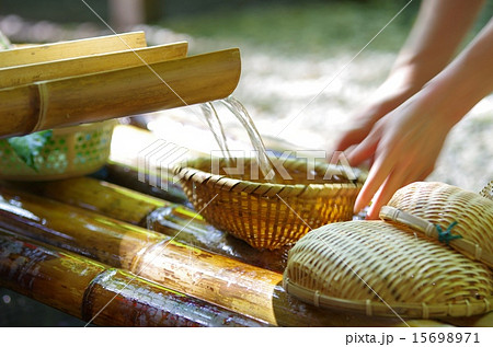 宮崎県高千穂峡の流し素麺の竹のトイと清水の流れに竹のザルをセットする女性の手 宮崎県高千穂峡の流し素麺の竹のトイと清水の流れに竹のザルをセットする女性の手 15698971