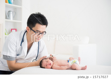 Good looking asian doctor and newborn baby on the clinic 15717027