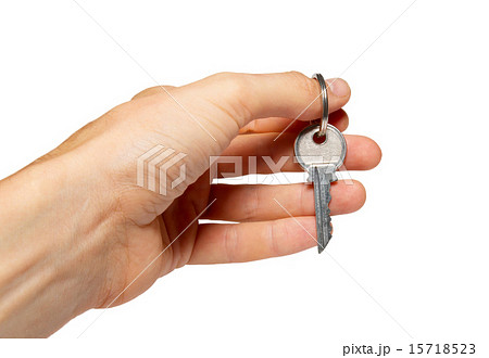 Silver key in a hand isolated on white. 15718523